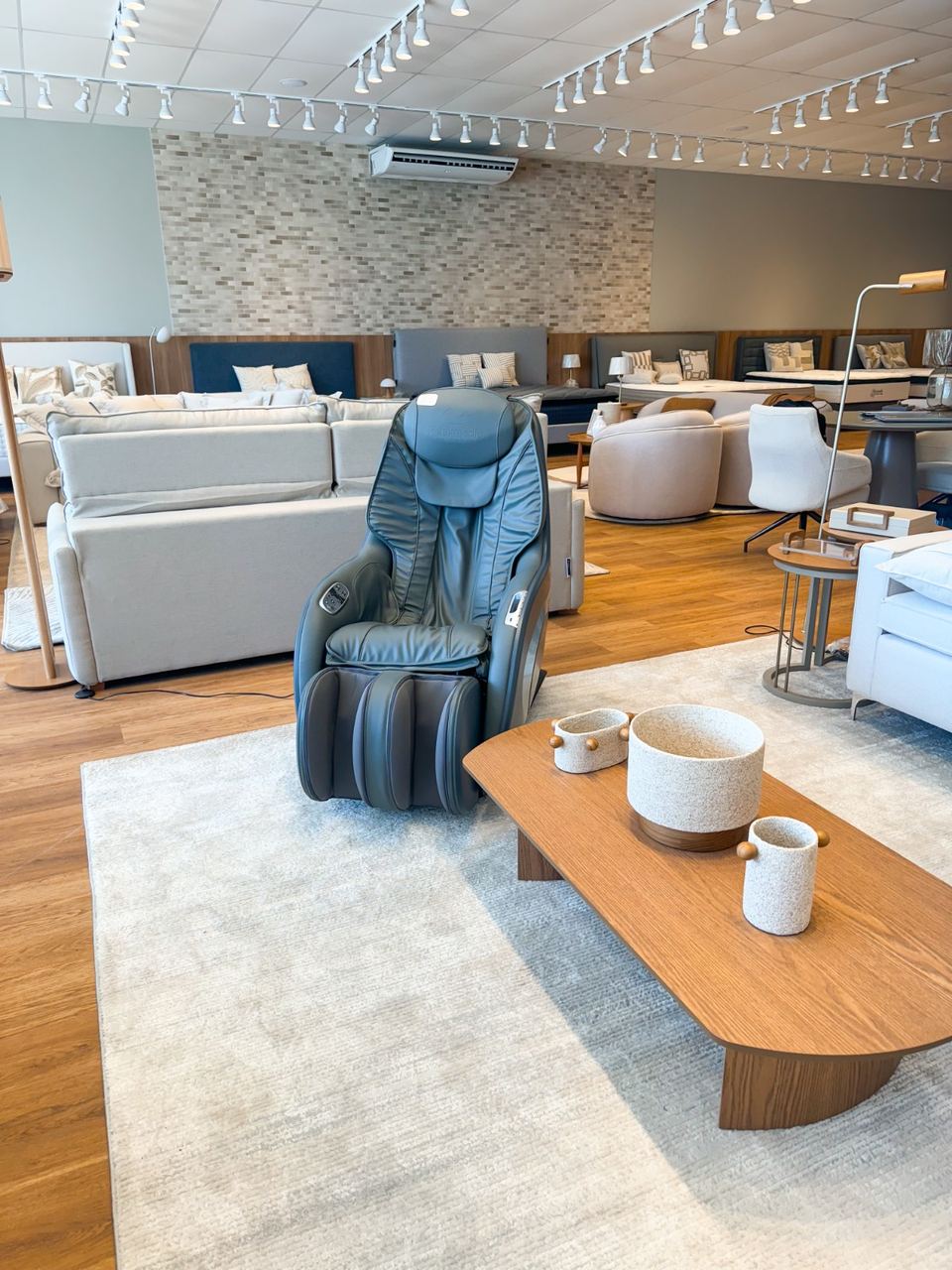 Área de estar do showroom Anjos Balsas — sofás e poltrona de massagem